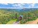 Breathtaking aerial view of a mountain cabin surrounded by towering pine trees at 10390 Hondah Dr, Littleton, CO 80127