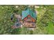 Aerial view of a charming cabin with a hot tub, wrap-around deck, nestled among lush trees at 10390 Hondah Dr, Littleton, CO 80127
