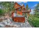 This mountain home has a hot tub with a view, a redwood exterior, and upper and lower decks for outdoor enjoyment at 10390 Hondah Dr, Littleton, CO 80127