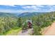 Charming exterior view of a secluded cabin nestled in a lush, green mountain landscape at 10390 Hondah Dr, Littleton, CO 80127