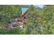 View of a charming cabin with a hot tub, wrap-around deck, nestled among lush trees at 10390 Hondah Dr, Littleton, CO 80127