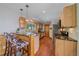 Well-lit kitchen with wood cabinets, granite countertops, stainless steel appliances, and bar seating at 10390 Hondah Dr, Littleton, CO 80127