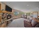 Spacious living room with stone fireplace, plush seating, and scenic views from large windows at 10390 Hondah Dr, Littleton, CO 80127