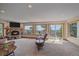 Bright living room featuring a stone fireplace, balcony access, and ample windows for scenic views at 10390 Hondah Dr, Littleton, CO 80127