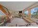 Inviting living room with a stone fireplace, balcony access, and comfortable seating, bathed in natural light at 10390 Hondah Dr, Littleton, CO 80127