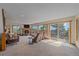Open-concept living area with access to a deck, featuring a stone fireplace and natural light at 10390 Hondah Dr, Littleton, CO 80127