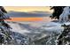 Scenic mountain view in winter, shrouded in fog, capturing a dramatic sunset against a snowy landscape at 10390 Hondah Dr, Littleton, CO 80127