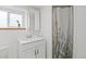 This bathroom features a modern white vanity, chrome faucet, and a shower with a floral curtain at 9551 W 38Th Ave, Wheat Ridge, CO 80033