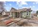 Green home with a cozy front porch and landscaped surroundings with great curb appeal at 9551 W 38Th Ave, Wheat Ridge, CO 80033