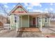 Charming home with a covered porch, red door, and quaint architectural details at 9551 W 38Th Ave, Wheat Ridge, CO 80033