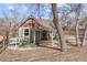 Charming home with a red door, complemented by a cozy front porch and mature trees at 9551 W 38Th Ave, Wheat Ridge, CO 80033