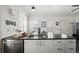 Kitchen island featuring a stainless steel dishwasher, an island sink and white cabinets at 9551 W 38Th Ave, Wheat Ridge, CO 80033