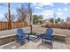 Blue Adirondack chairs with a table, creating a relaxing outdoor seating area on a stone patio at 9551 W 38Th Ave, Wheat Ridge, CO 80033