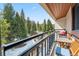 Private balcony overlooking the evergreens, equipped with a grill and seating for outdoor dining at 405 Village Rd # 405, Breckenridge, CO 80424