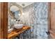 Stylish half-bathroom featuring a wooden countertop, a round sink, and a grey tiled wall at 405 Village Rd # 405, Breckenridge, CO 80424