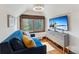 Cozy bedroom features a large window, comfortable blue sofa, and entertainment center with TV at 405 Village Rd # 405, Breckenridge, CO 80424