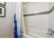 Bright bathroom featuring white tile, a sleek tub, and a stylish shower curtain, blending modern convenience with a touch of elegance at 1265 Elizabeth St # 305, Denver, CO 80206
