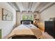 Cozy bedroom featuring a comfortable bed, hardwood floors, exposed beams, and natural light at 1265 Elizabeth St # 305, Denver, CO 80206