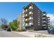 Brick apartment building featuring multiple balconies, front entrance, and manicured landscaping at 1265 Elizabeth St # 305, Denver, CO 80206