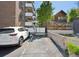 Parking area behind a brick building with a white car parked, showcasing convenient access and modern living at 1265 Elizabeth St # 305, Denver, CO 80206