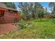 Spacious backyard with lush lawn, mature trees, and a cozy deck area at 29090 Golf Way, Evergreen, CO 80439