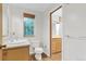 Bathroom with vanity, toilet, and window, alongside a view of another bathroom at 29090 Golf Way, Evergreen, CO 80439