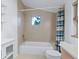 Bathroom featuring a tiled bathtub, toilet, and shelving at 29090 Golf Way, Evergreen, CO 80439