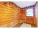 Cozy entryway featuring wood paneled walls, a built-in bench, and coat racks by the door at 29090 Golf Way, Evergreen, CO 80439