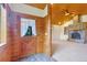 Inviting foyer with a stone fireplace and wood paneling, leading into a spacious living area at 29090 Golf Way, Evergreen, CO 80439