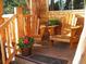 Cozy front porch with wooden chairs and flowers, perfect for enjoying the peaceful surroundings at 29090 Golf Way, Evergreen, CO 80439