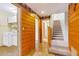 Hallway and staircase featuring wood paneling, and access to laundry room at 29090 Golf Way, Evergreen, CO 80439