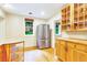 Eat-in kitchen with wood cabinets, stainless steel fridge, and window with natural light and view at 29090 Golf Way, Evergreen, CO 80439