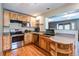 Well-lit kitchen featuring wooden cabinets, modern appliances, and a granite countertop bar with storage at 29090 Golf Way, Evergreen, CO 80439