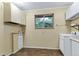 Functional laundry room with ample cabinet space and natural light from the window at 29090 Golf Way, Evergreen, CO 80439
