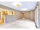 Spacious living room with wood paneled walls, carpet floors, and a pass-through window to the kitchen at 29090 Golf Way, Evergreen, CO 80439