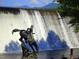 Scenic waterfall view featuring a bronze statue of a Personal riding a horse in Evergreen, Colorado at 29090 Golf Way, Evergreen, CO 80439