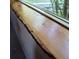 Close-up of a natural wood window ledge with a view of the surrounding forest at 29090 Golf Way, Evergreen, CO 80439