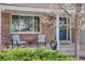 Inviting front porch with brick accents, seating area, and a beautifully decorated front door at 6708 S Niagara Ct, Centennial, CO 80112