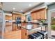 Well-lit kitchen with wood cabinets, stainless steel appliances, granite counters, island seating, and hardwood floors at 6708 S Niagara Ct, Centennial, CO 80112