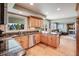 Spacious kitchen with granite countertops, stainless steel dishwasher, and hardwood floors seamlessly transitions to the living room at 6708 S Niagara Ct, Centennial, CO 80112