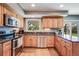 Modern kitchen with stainless steel appliances, wood cabinets, granite counters, and a window overlooking the backyard at 6708 S Niagara Ct, Centennial, CO 80112