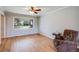 Bright living room featuring hardwood floors, a ceiling fan, and a large window offering ample natural light at 6708 S Niagara Ct, Centennial, CO 80112