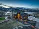 Beautiful exterior shot of the house with mountain views at dusk with manicured lawn and mature landscaping at 8727 Hunters Hill Ln, Littleton, CO 80125