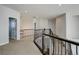 Upstairs hallway boasts a beautiful wrought iron railing and neutral carpeting leading to the bedrooms at 8727 Hunters Hill Ln, Littleton, CO 80125