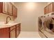 Functional laundry room with cabinets, sink, and modern washer and dryer for convenience at 8727 Hunters Hill Ln, Littleton, CO 80125