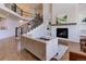 Open concept living room features fireplace, staircase and view into other rooms at 8727 Hunters Hill Ln, Littleton, CO 80125