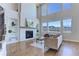 Bright living room with fireplace, built-in shelving, large windows, and hardwood floors at 8727 Hunters Hill Ln, Littleton, CO 80125
