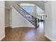 Sweeping staircase with wrought iron railing, hardwood floors, and views into living room at 8727 Hunters Hill Ln, Littleton, CO 80125