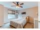 Bedroom featuring neutral walls, ceiling fan and carpeted floor with large window and artwork at 10652 Hyacinth St, Highlands Ranch, CO 80129