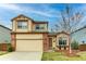 Two-story home with tan siding, brick accents, and a well-maintained front yard at 10652 Hyacinth St, Highlands Ranch, CO 80129